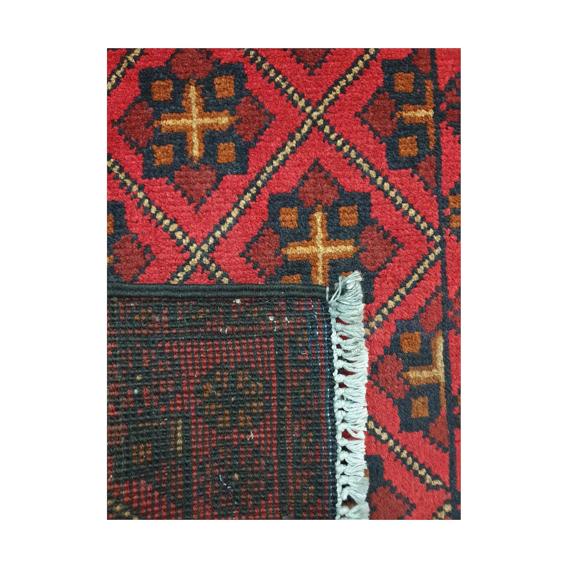 Folded corner detail of Afghan Khal Mohammadi wool rug showing the back, fringe and red front pattern
