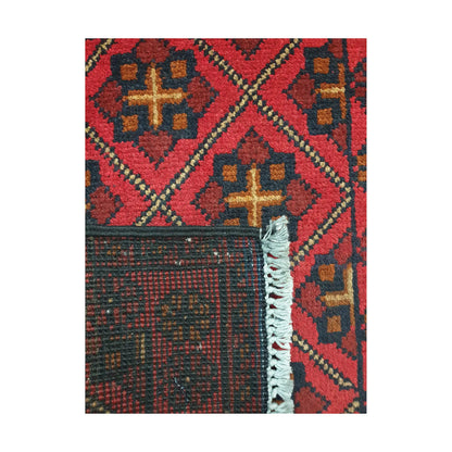 Folded corner detail of Afghan Khal Mohammadi wool rug showing the back, fringe and red front pattern