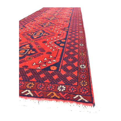 Angled view of Afghan Khal Mohammadi runner showing its deep red medallion field, layered geometric borders and white fringe