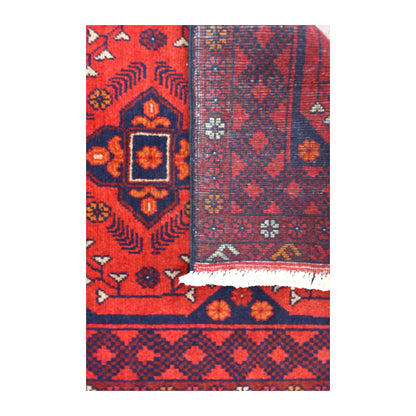 Folded-corner detail of Khal Mohammadi runner showing the reverse weave beside its deep red patterned front and white fringe
