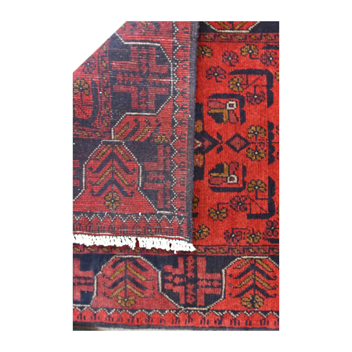 Folded-corner detail of Khal Mohammadi runner showing the reverse weave beside its deep red patterned front and white fringe