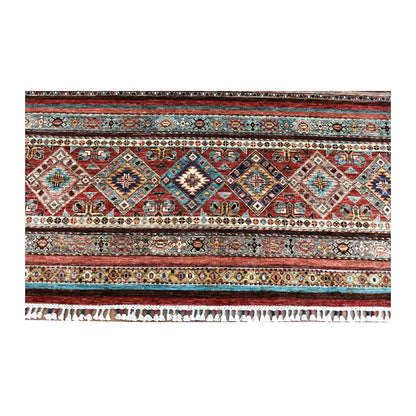 Fringe and end-border detail of Khurjeen rug with diamond medallions in rust red, turquoise, navy and ivory