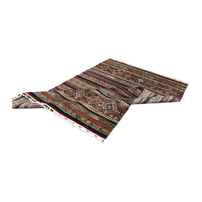 Folded view of Afghan Khurjeen hand-knotted wool rug showing its layered bands, diamond motifs and fringe