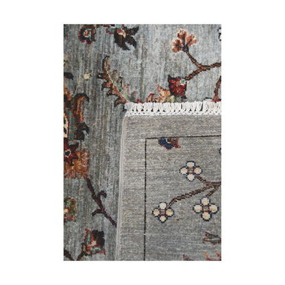 Folded corner detail of Afghan Khurjeen runner rug showing the back of the rug, fringe and grey floral front pattern