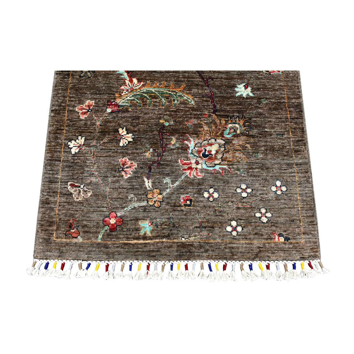 End detail of Afghan Khurjeen runner showing a large botanical motif and multicoloured fringed finish