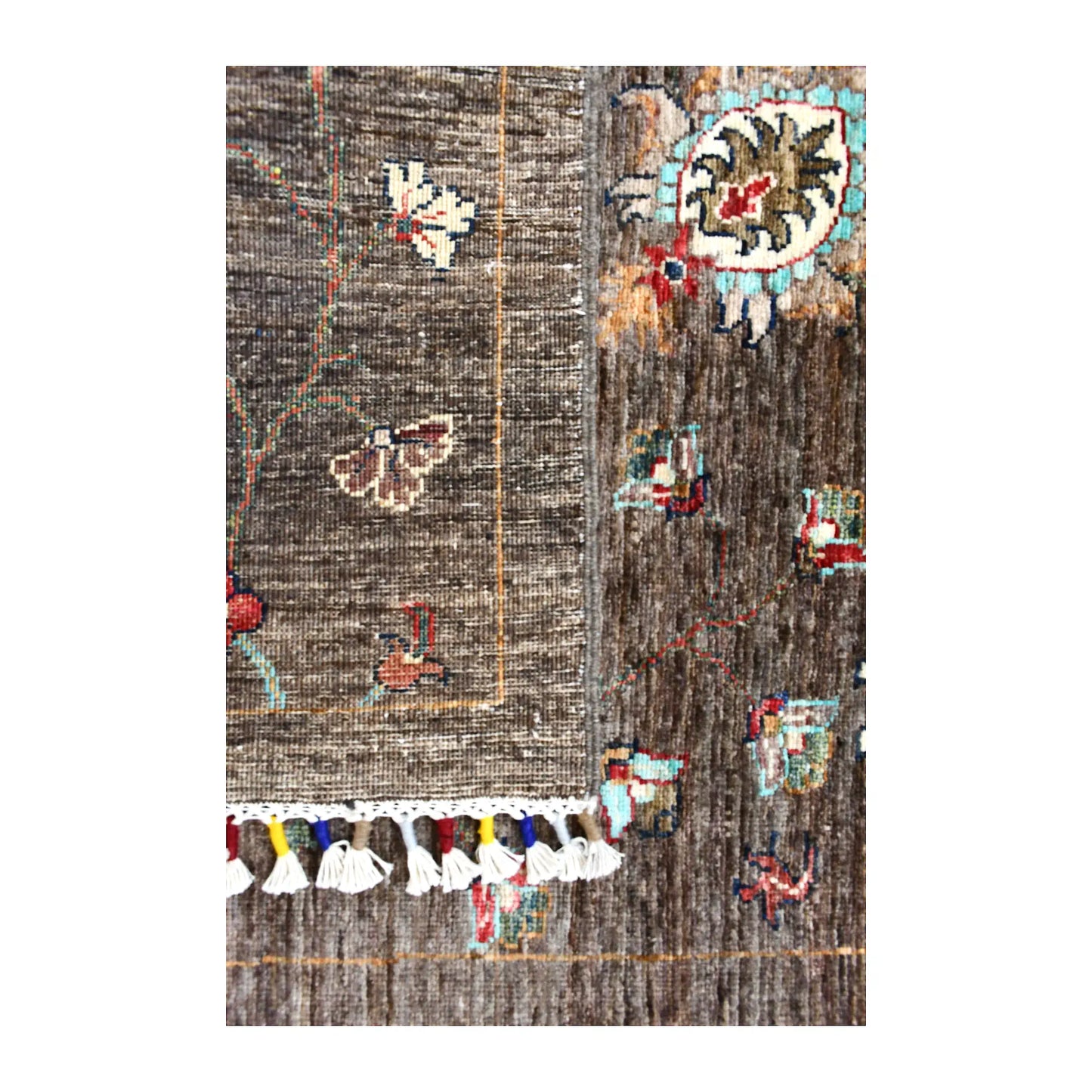 Folded fringe end of Afghan Khurjeen runner showing the patterned face, reverse weave and multicoloured finishing