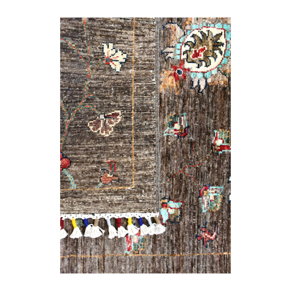 Folded fringe end of Afghan Khurjeen runner showing the patterned face, reverse weave and multicoloured finishing