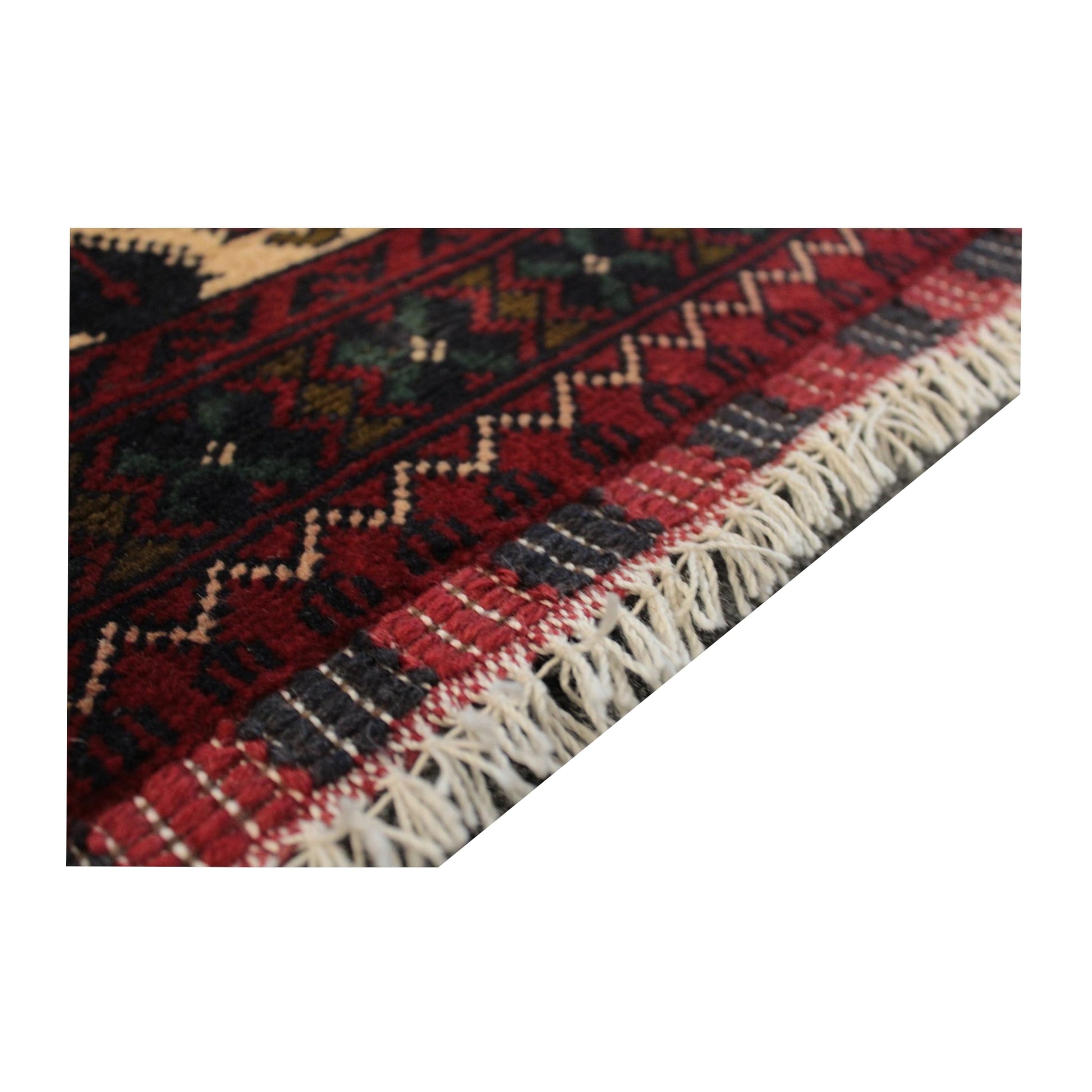 Angled end detail of Afghan Kunduz rug showing the flatwoven finishing band and visible fringe