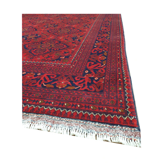 Angled border and fringe detail of Afghan Kunduz rug showing deep red wool pile, navy edging and floral motifs