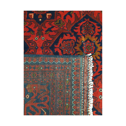 Folded corner detail of Afghan Kunduz rug showing the back of the rug, fringe and deep red front pattern