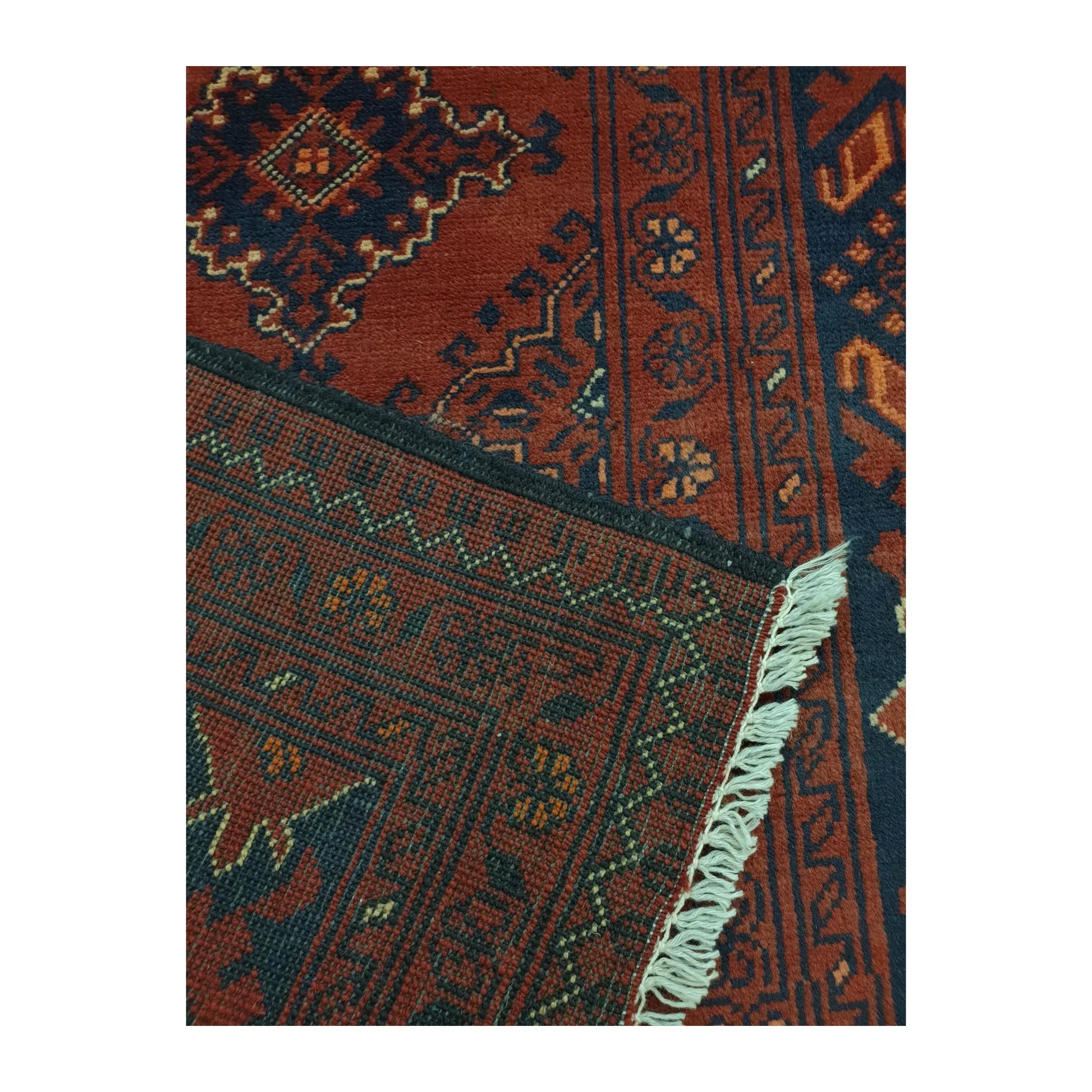 Folded-corner detail of Afghan Kunduz runner rug showing wool pile, reverse weave, layered border and fringe