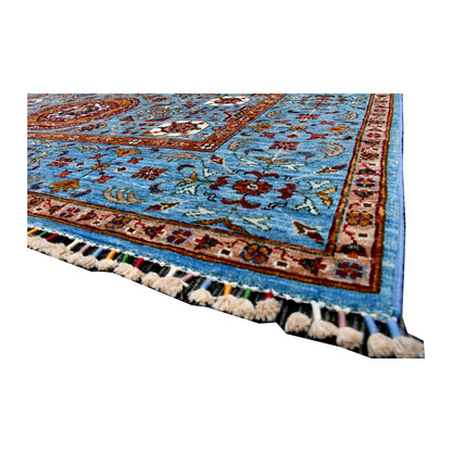 Angled corner and fringe view of Afghan Mamluk wool rug showing sky-blue field, rust border detail and tassel fringe