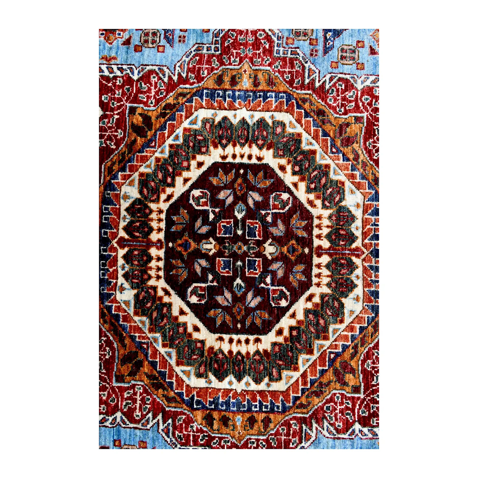 Close central medallion detail of Afghan Mamluk hand-knotted wool rug showing ivory, rust red, dark brown and blue patterning