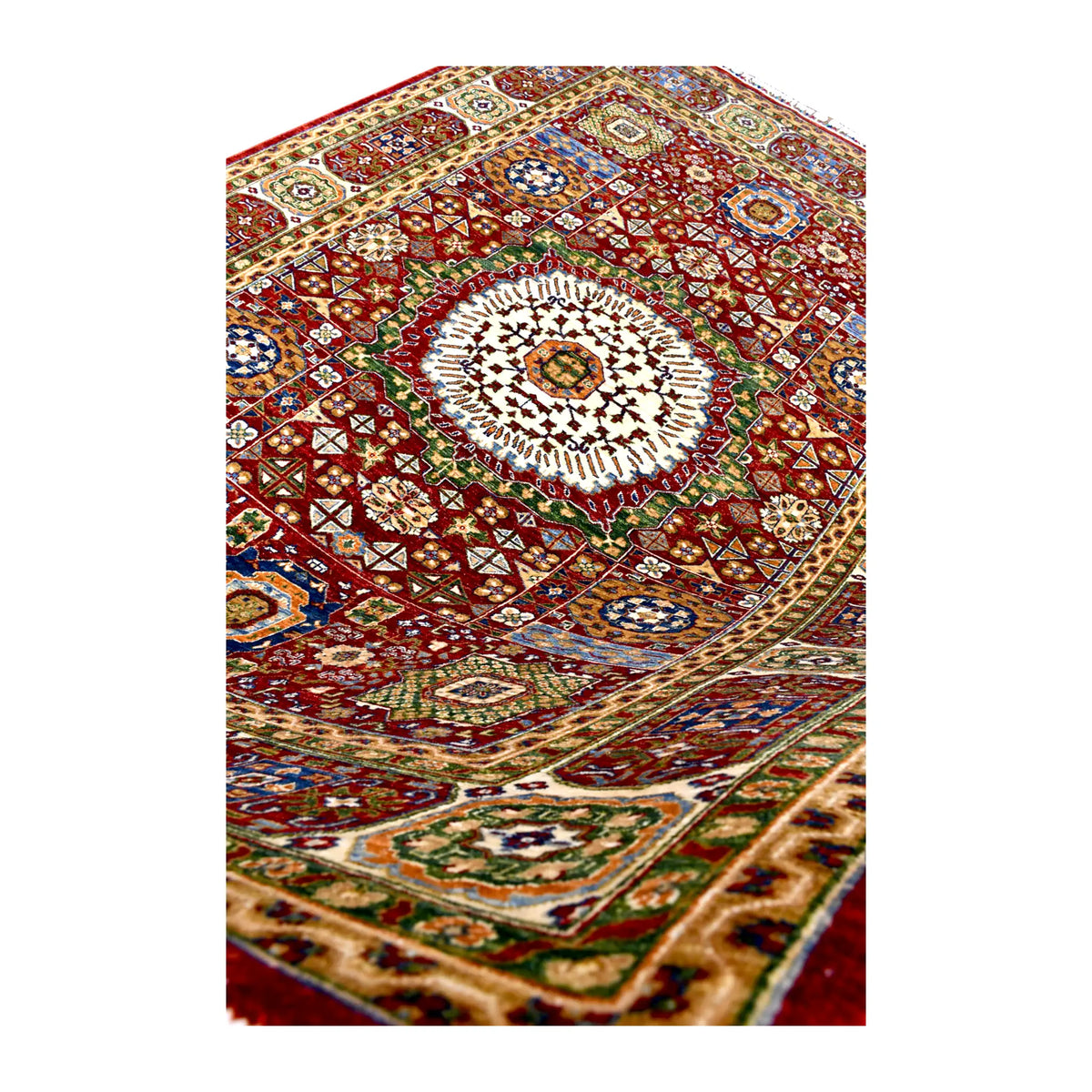 Angled detail of the cream central medallion, red geometric field and richly patterned border.