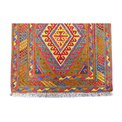 Fringe-end detail of Mashwani runner showing a concentric diamond medallion, colourful angular borders and light-grey fringe