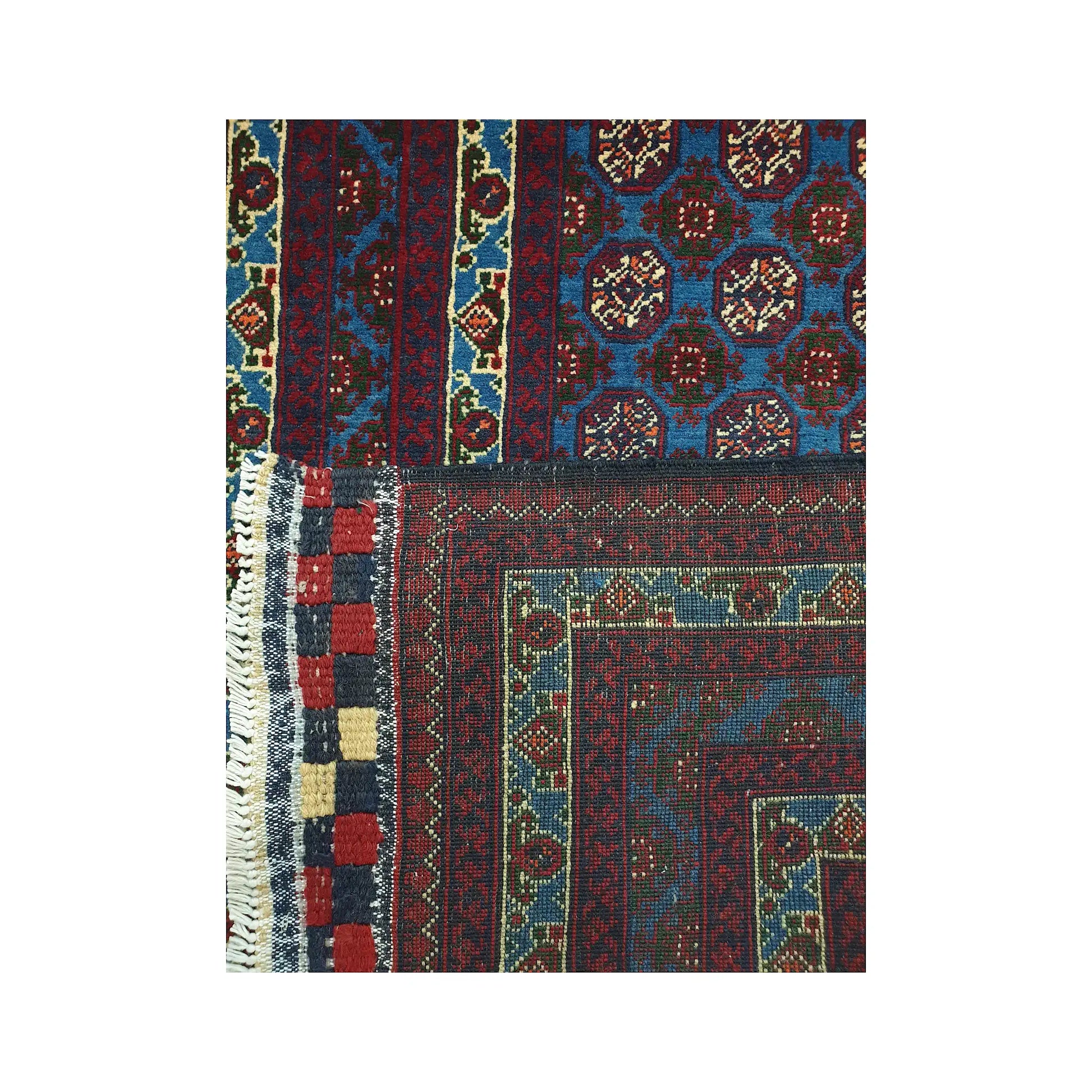 Folded corner detail of Afghan Roshnai runner rug showing the back of the rug, fringe and blue front pattern