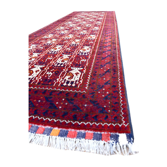 Angled view of Afghan Roshnai wool runner showing ivory motifs, navy and plum borders, striped end finish and white fringe