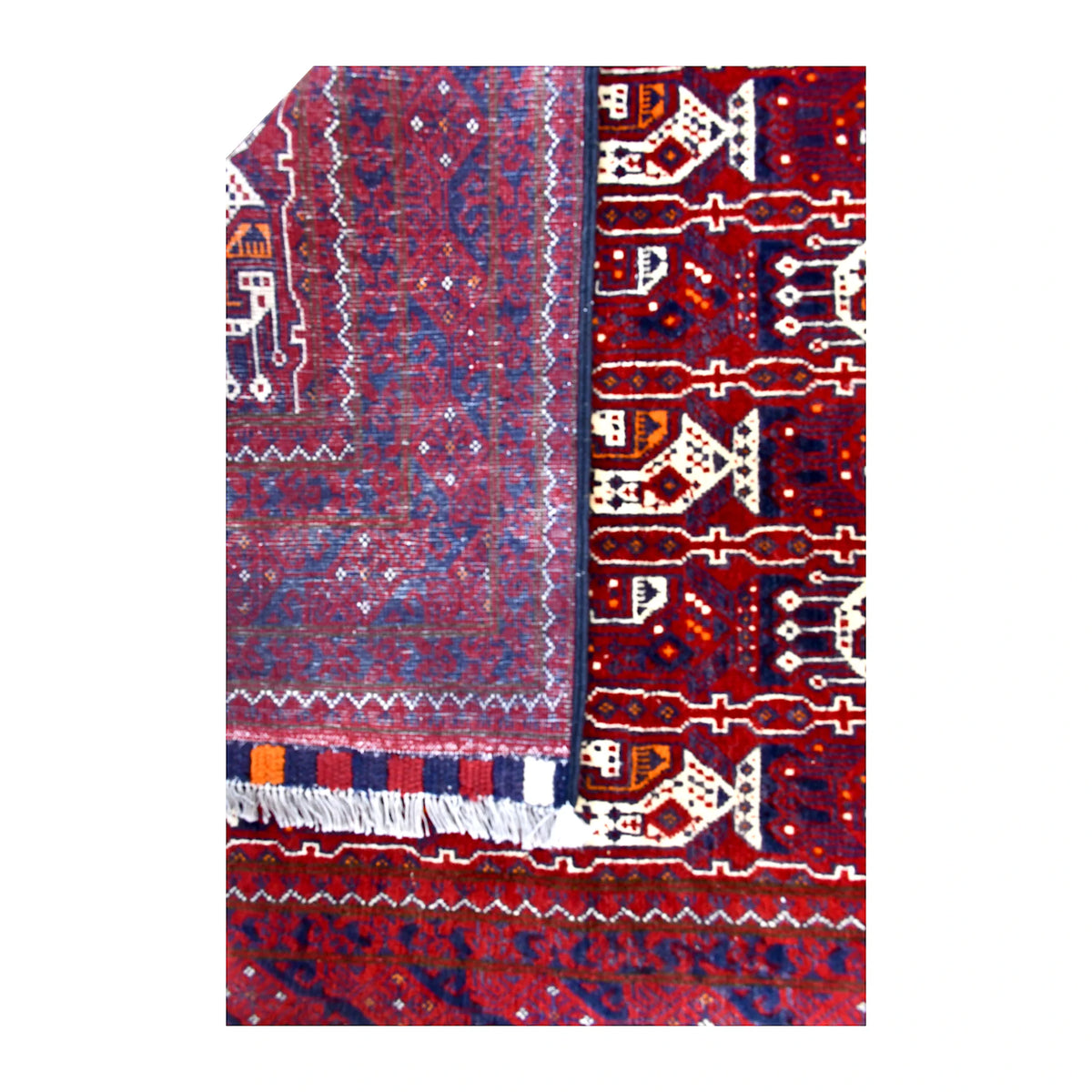 Folded-corner detail of Afghan Roshnai wool runner showing the reverse weave beside its patterned front, striped end finish and white fringe
