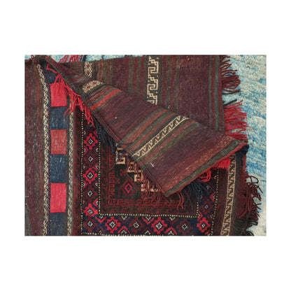 Folded reverse view of Afghan saddle bag showing burgundy striped flatweave, ivory geometric bands and fringe