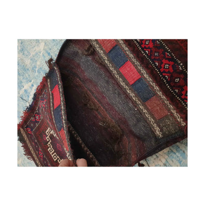 Open compartment view showing dark flatweave and red, navy and ivory woven bands on the Afghan saddle bag