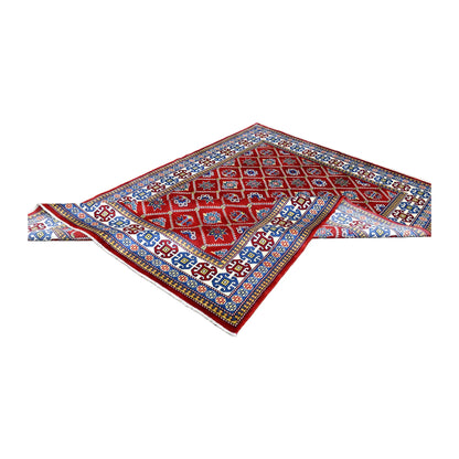Folded view of Afghan Shirvan hand-knotted wool rug showing its red patterned field, layered borders and pale fringe