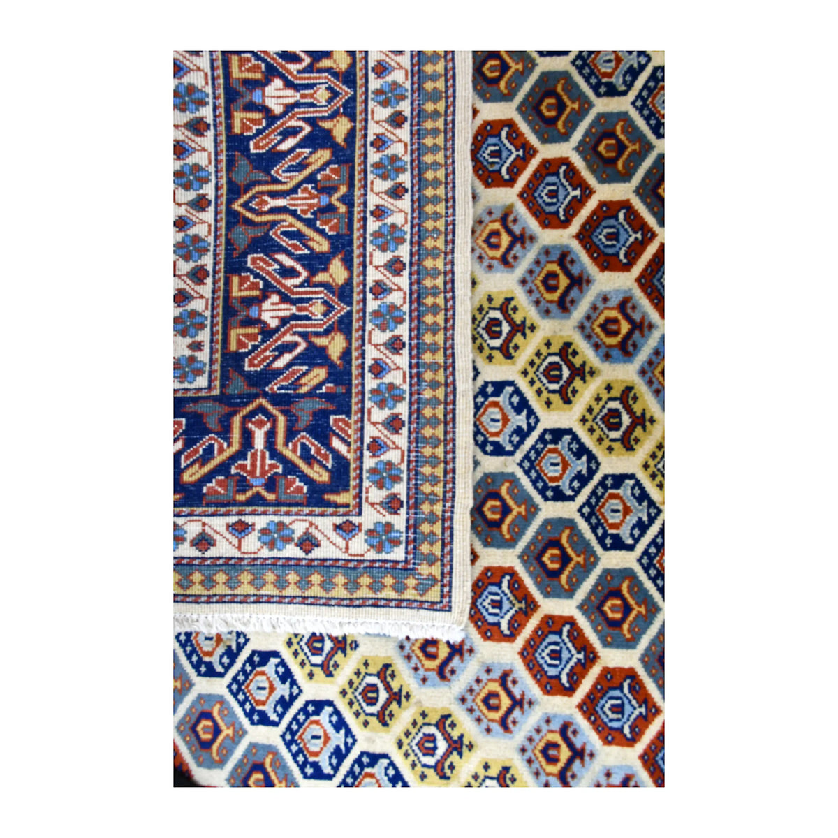Folded-corner detail of Afghan Shirvan rug showing the reverse weave beside the geometric front and deep navy border