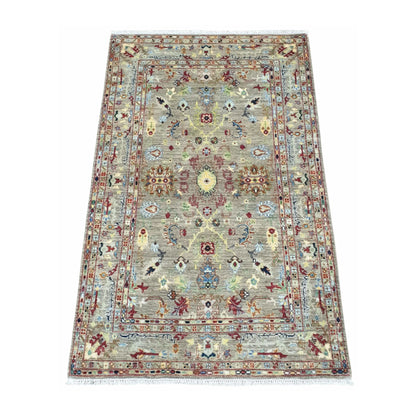 Angled view of Afghan Sultani wool rug with layered borders and pale blue accents, 185 x 119 cm