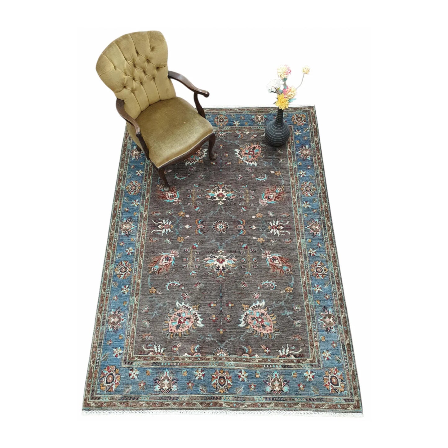 Afghan Sultani hand-knotted rug styled with chair and vase showing blue border and floral field