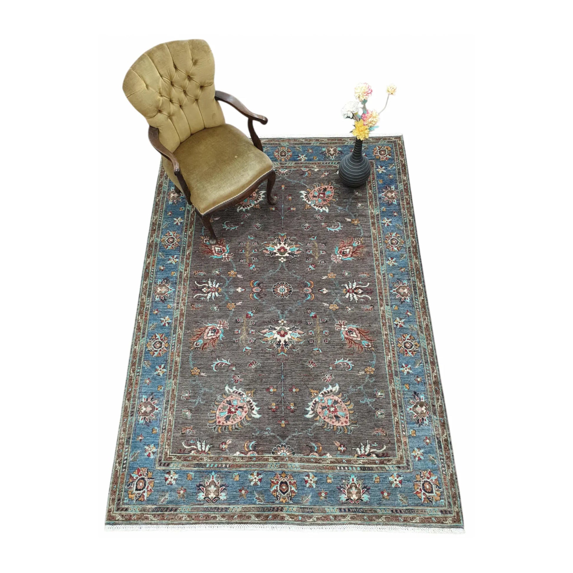 Afghan Sultani hand-knotted rug styled with chair and vase showing blue border and floral field