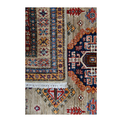 Folded-corner detail of Super Kazak rug showing the reverse weave, patterned pile and pale fringe
