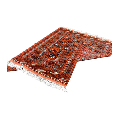 Folded view of Afghan Turkmen Tekke wool rug showing its patterned pile, borders and reverse weave