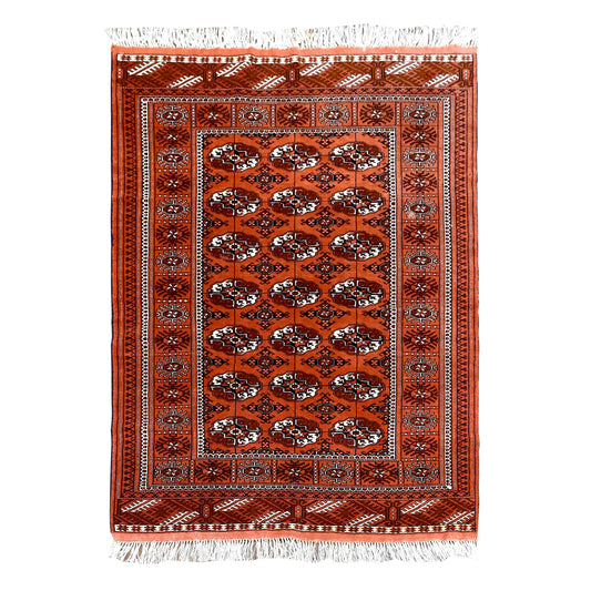 Full view of Afghan Turkmen Tekke hand-knotted wool rug with a rusty-orange field of repeated gul motifs, 167 x 125 cm