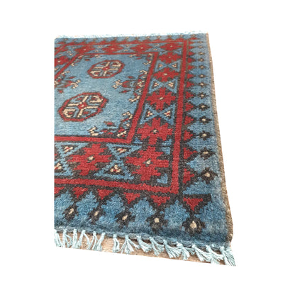 Fringe and border detail of Afghan Turkoman blue wool rug showing red stepped border and dark geometric edging