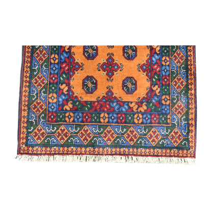 Fringe-end detail of Afghan Turkoman runner showing dark medallions, colourful geometric border bands and pale fringe