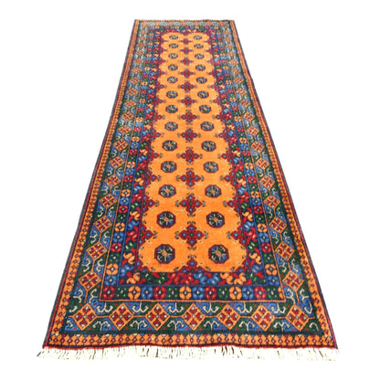 Full view of Afghan Turkoman wool runner with golden ochre field, repeating dark medallions and multicoloured borders, 286 x 85 cm