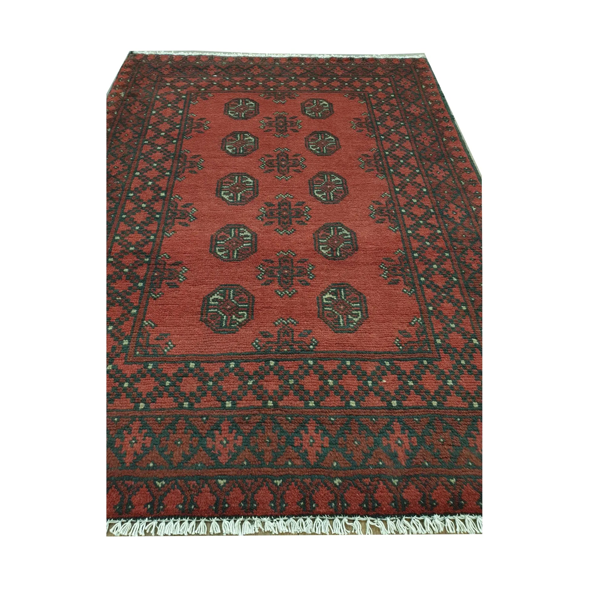 Angled full view of Afghan Turkoman wool rug showing red field, black border and cream geometric details
