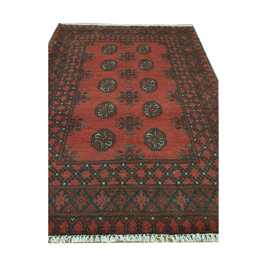 Angled full view of Afghan Turkoman wool rug showing red field, black border and cream geometric details