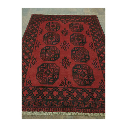 Angled full view of Afghan Turkoman hand-knotted rug showing octagonal gul motifs