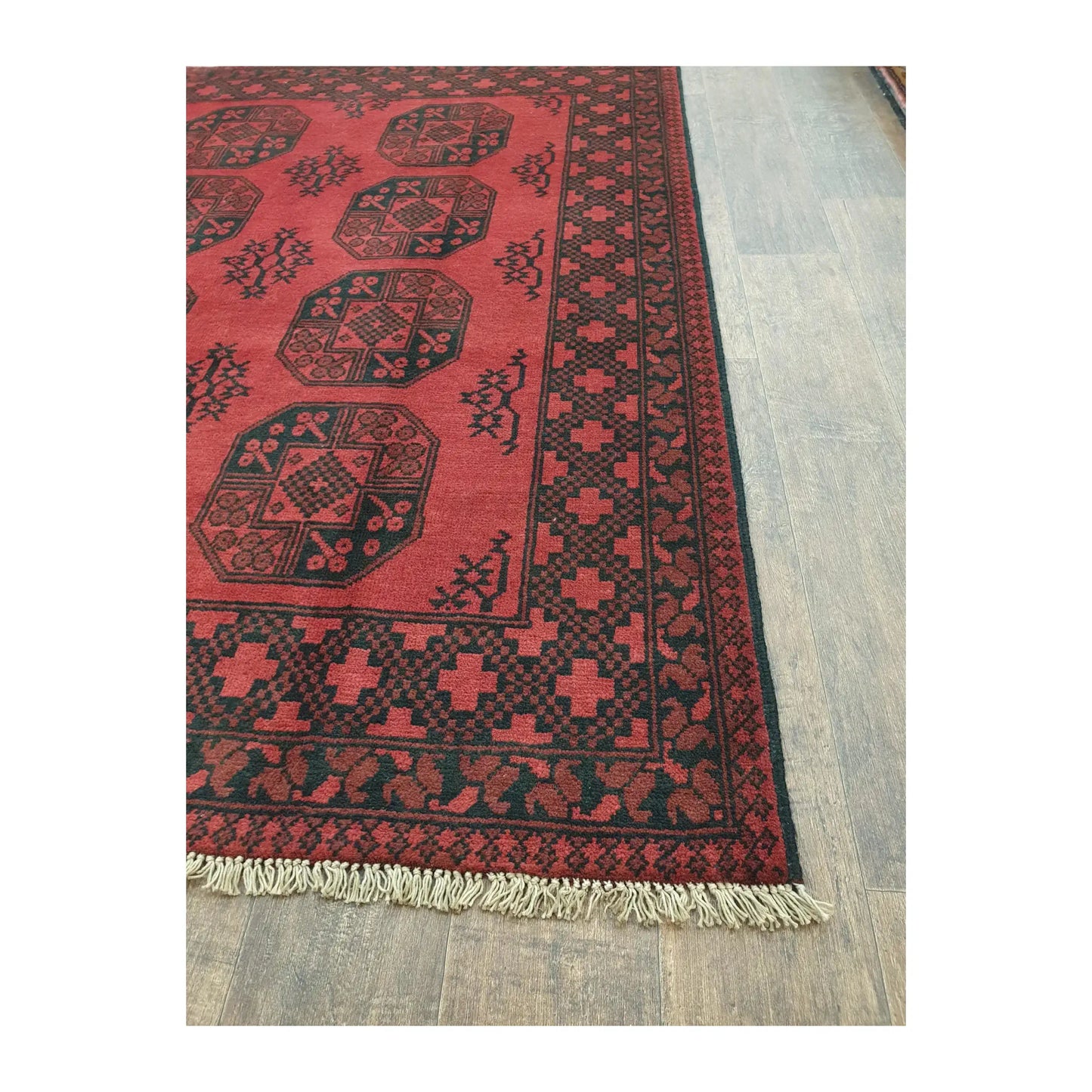 Border and fringe detail of Afghan Turkoman wool rug with red geometric pattern