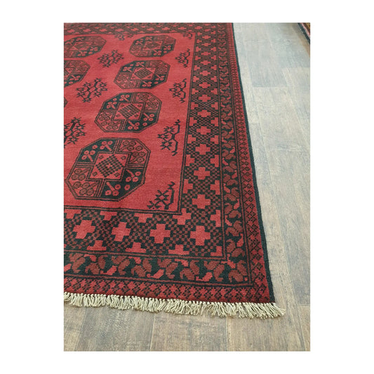 Border and fringe detail of Afghan Turkoman wool rug with red geometric pattern