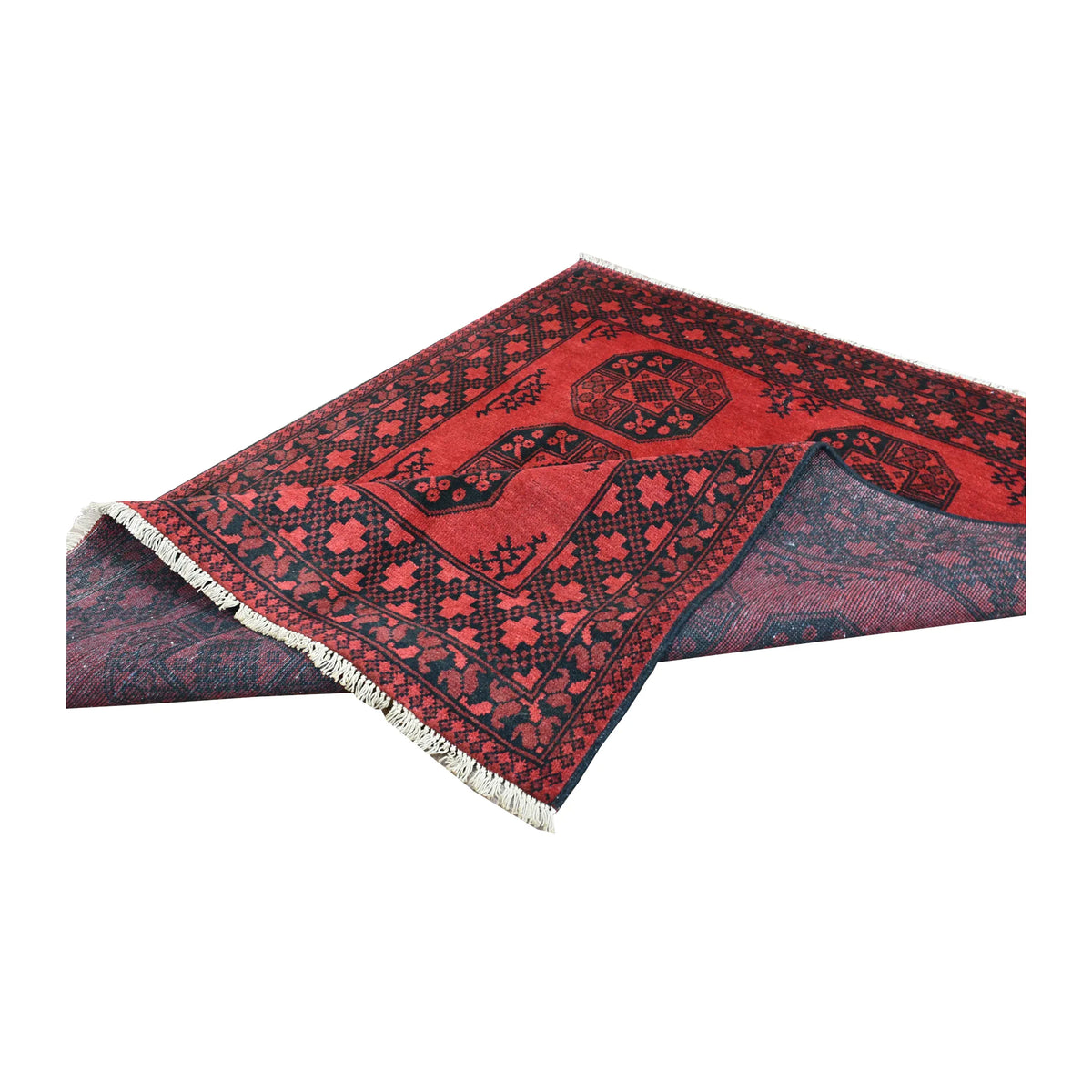 Folded view of Afghan Turkoman rug showing its red gul field, layered dark borders and pale fringe