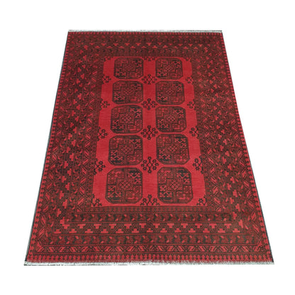 Angled view of Afghan Turkoman hand-knotted wool rug showing red field, border and fringe, 238 x 171 cm