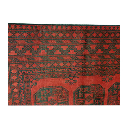 Field and border detail of Afghan Turkoman wool rug showing red pile, dark motifs and layered geometric border