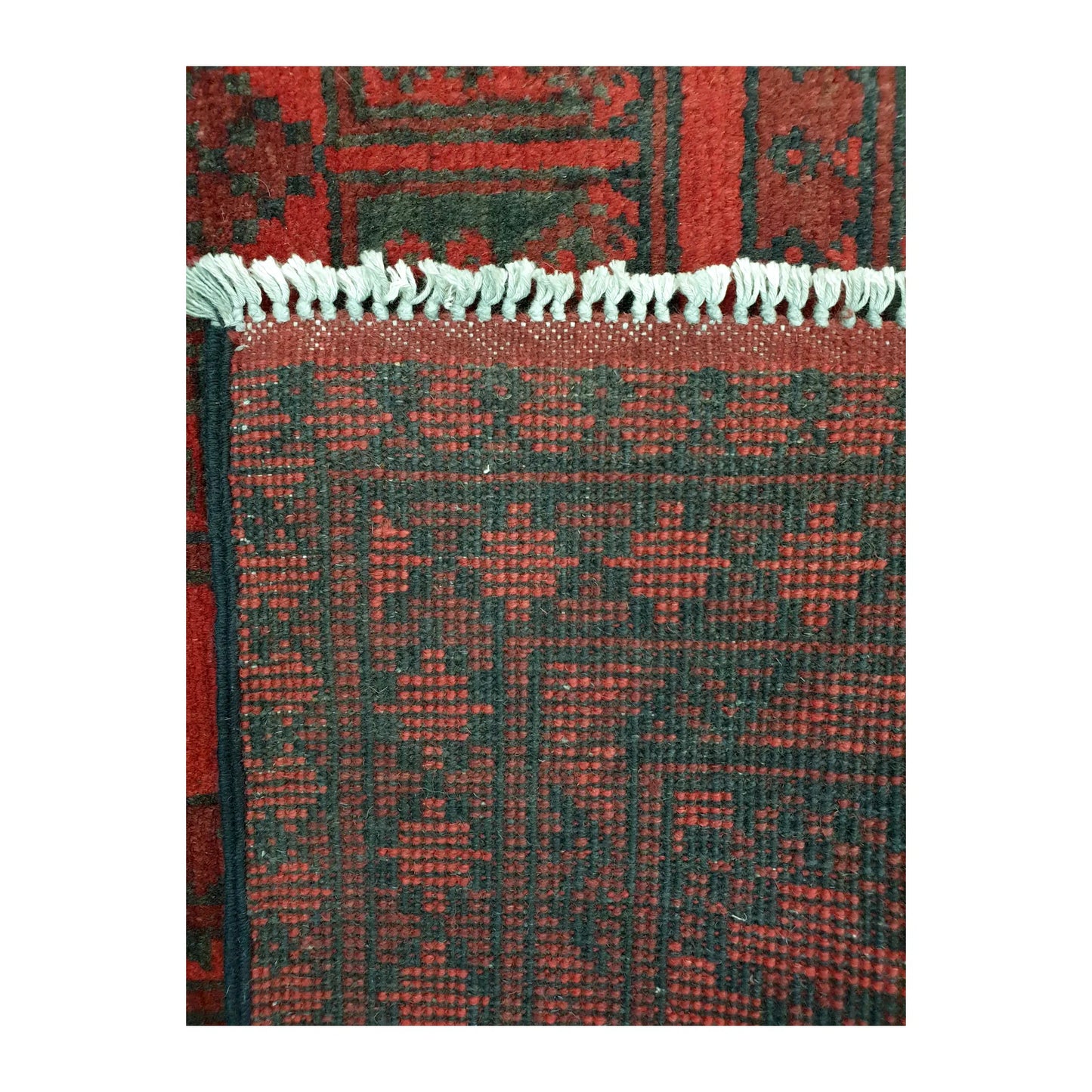 Reverse-weave detail of Afghan Turkoman wool rug showing back structure, fringe and hand-knotted pattern