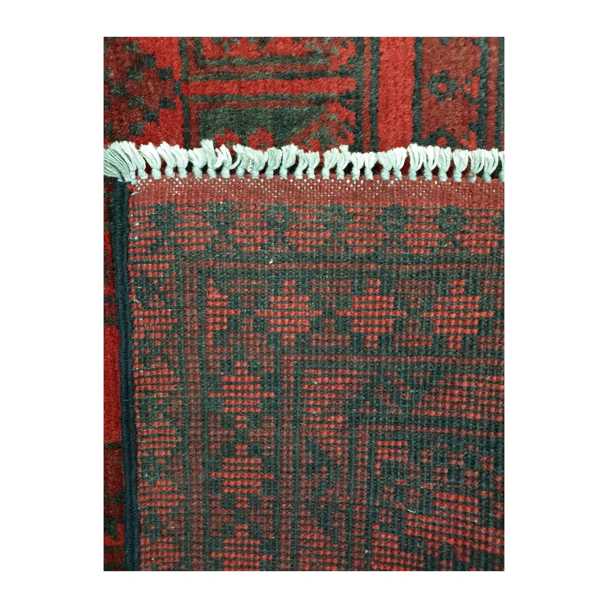 Reverse-weave detail of Afghan Turkoman wool rug showing back structure, fringe and hand-knotted pattern