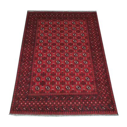 Angled view of Afghan Turkoman hand-knotted wool rug showing red field, geometric border and ivory fringe, 240 x 168 cm