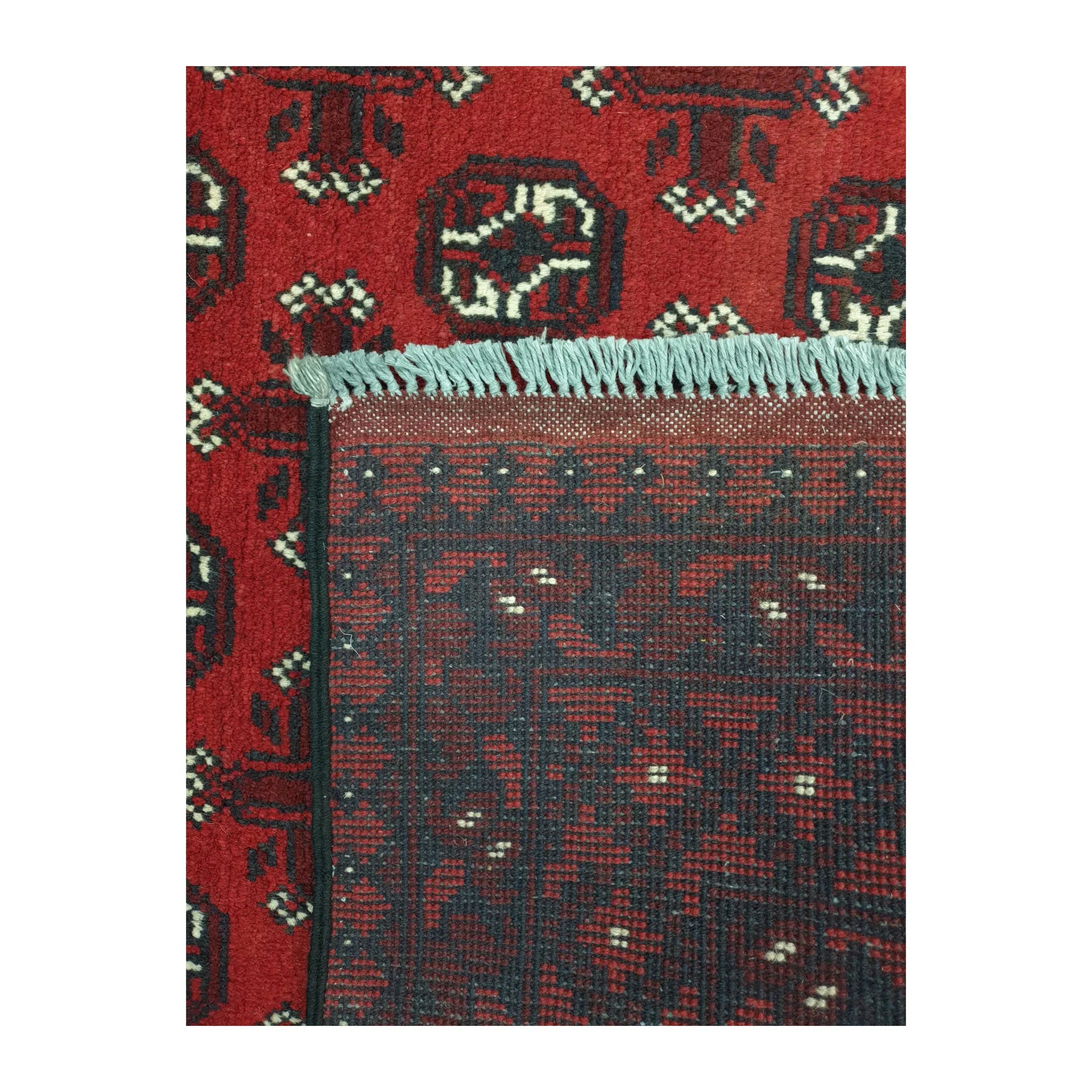 Reverse-weave and fringe detail of Afghan Turkoman wool rug showing back structure and hand-knotted pattern