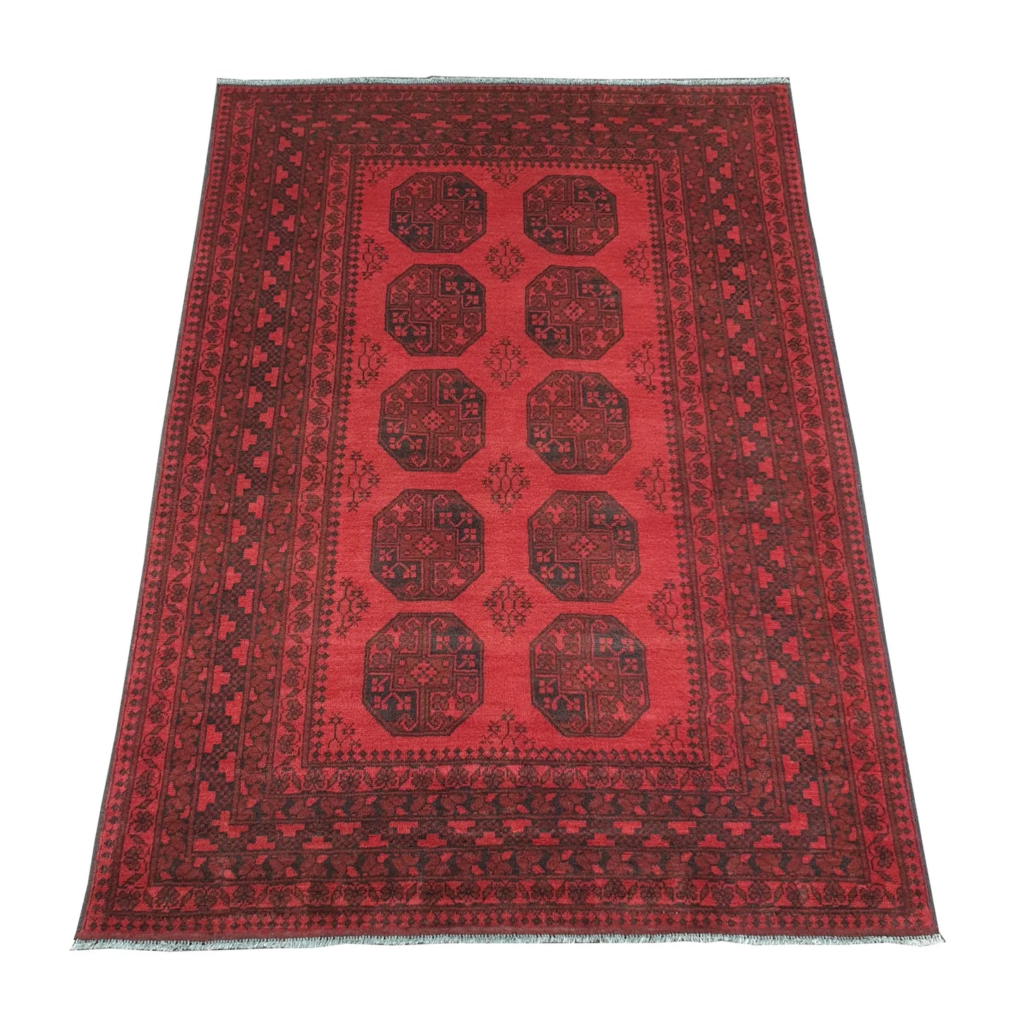 Angled view of Afghan Turkoman hand-knotted wool rug showing red field, wide border and ivory fringe, 240 x 176 cm