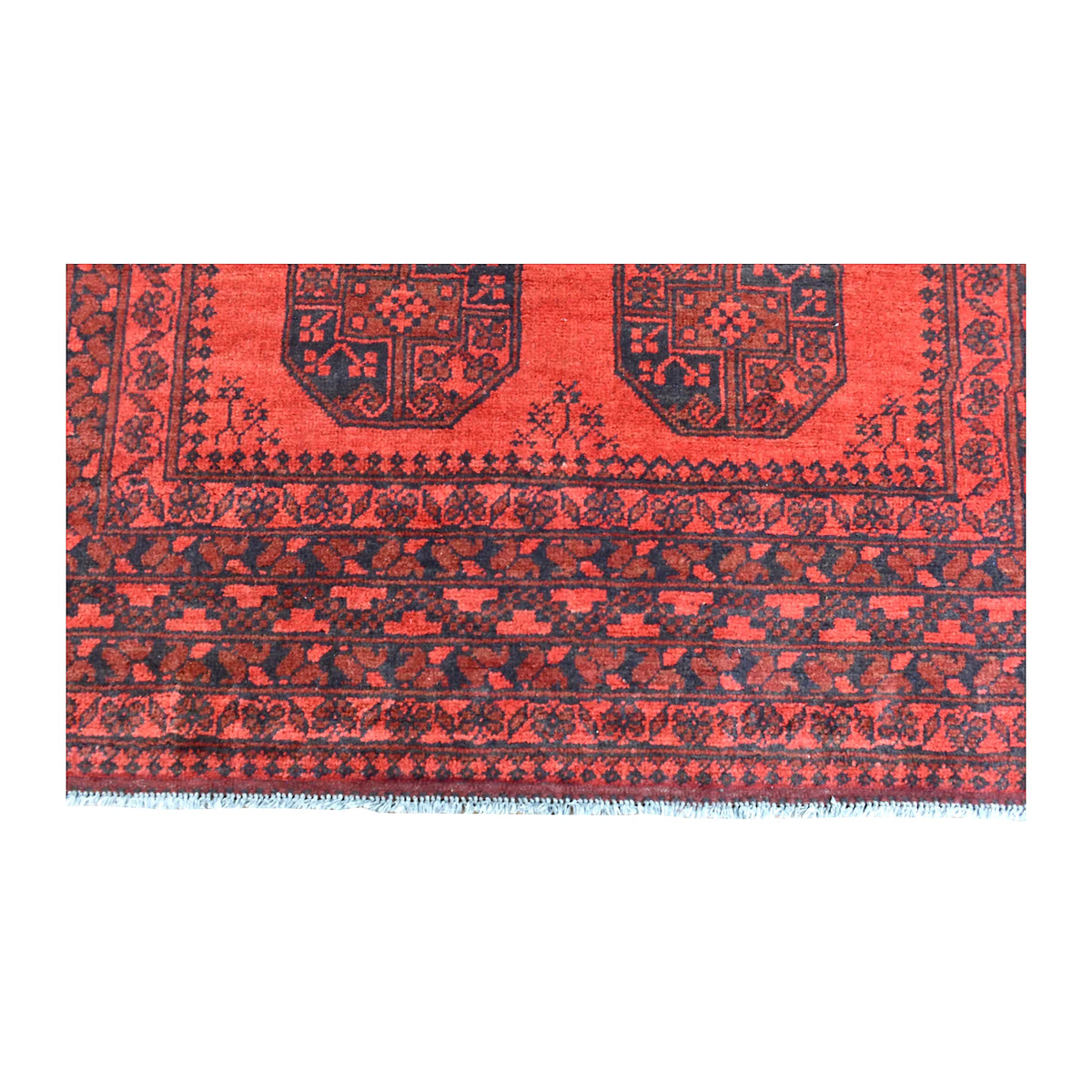 End-border detail of Afghan Turkoman rug showing dark diamond bands beneath the red gul field and white fringe