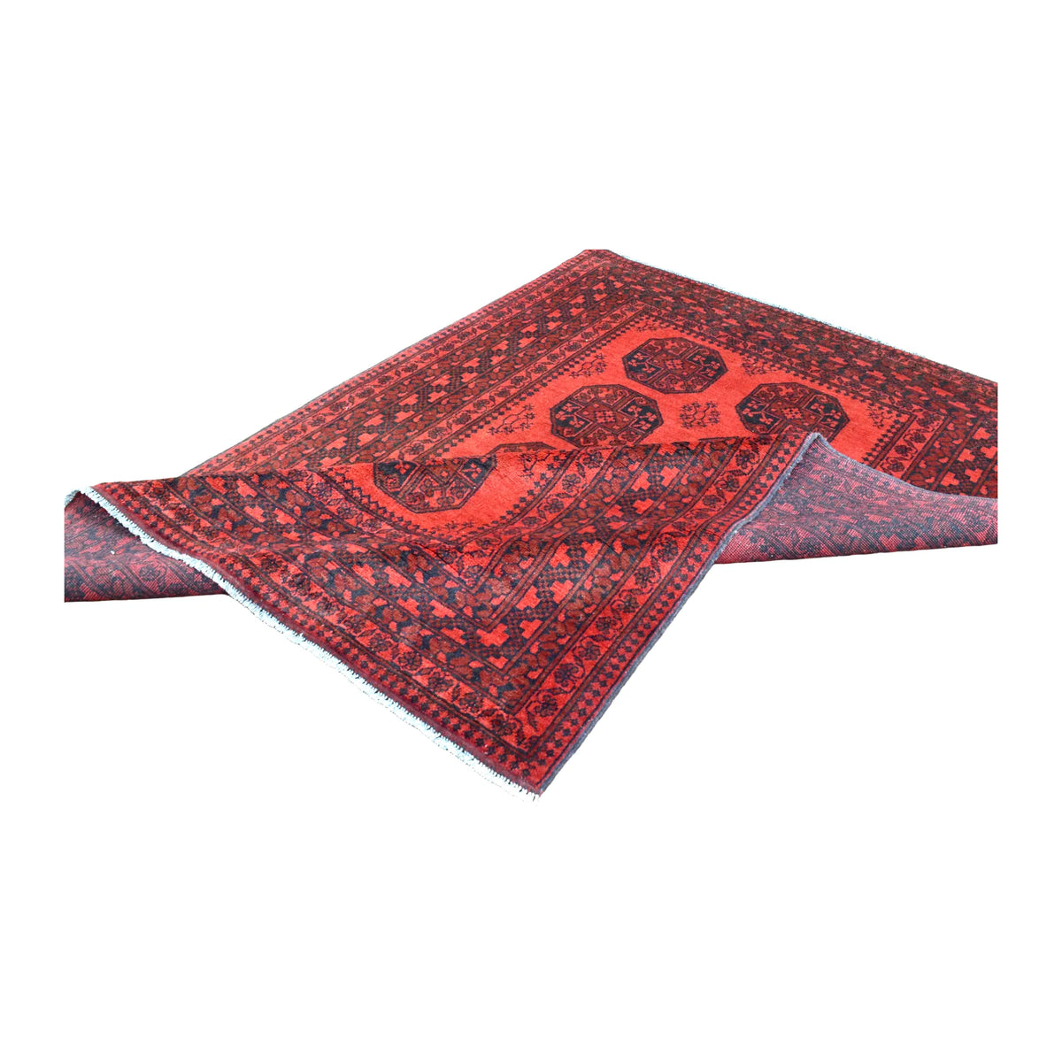 Folded view of Afghan Turkoman wool rug showing its red gul field, dark geometric border and reverse